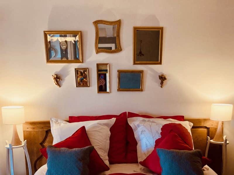 Chambre dhôtes chaleureuse avec lit douillet et décor mural élégant.