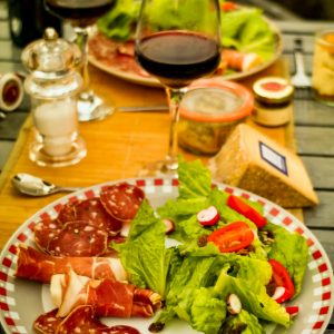 Dégustation de charcuterie et vin rouge dans un hébergement insolite en Midi-Pyrénées.