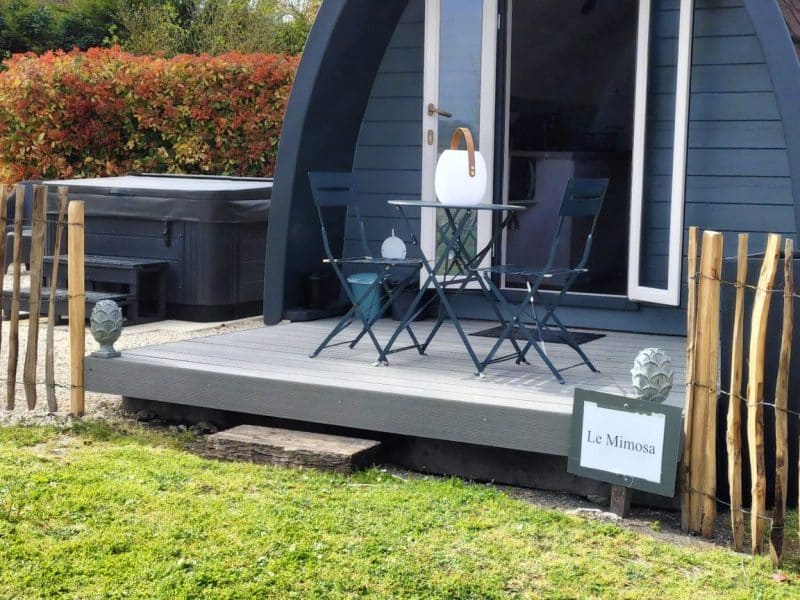 Cabane moderne en bois avec terrasse, entourée de verdure à Nouvelle-Aquitaine.