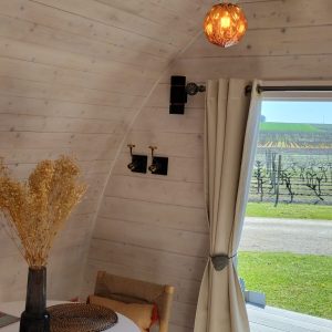 Hébergement insolite en Nouvelle-Aquitaine : intérieur lumineux avec table ronde et vue sur vignes.