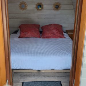 Hébergement insolite en Nouvelle-Aquitaine : chambre cocooning avec décor chaleureux et miroirs.