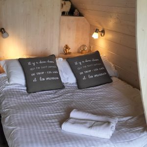 Chalet en bois cosy avec lit double et décor chaleureux à Nouvelle-Aquitaine.