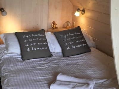 Chalet en bois cosy avec lit double et décor chaleureux à Nouvelle-Aquitaine.