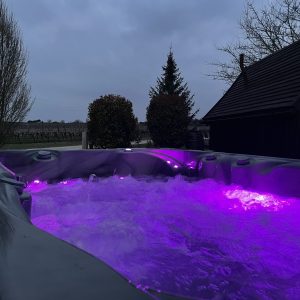 Hébergement insolite en Nouvelle-Aquitaine avec un jacuzzi lumineux sous un ciel nuageux.
