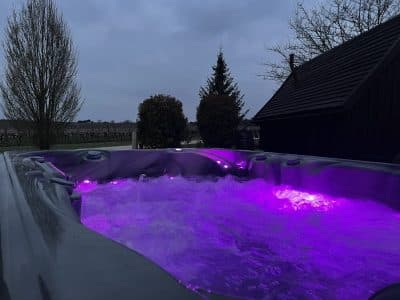 Hébergement insolite en Nouvelle-Aquitaine avec un jacuzzi lumineux sous un ciel nuageux.
