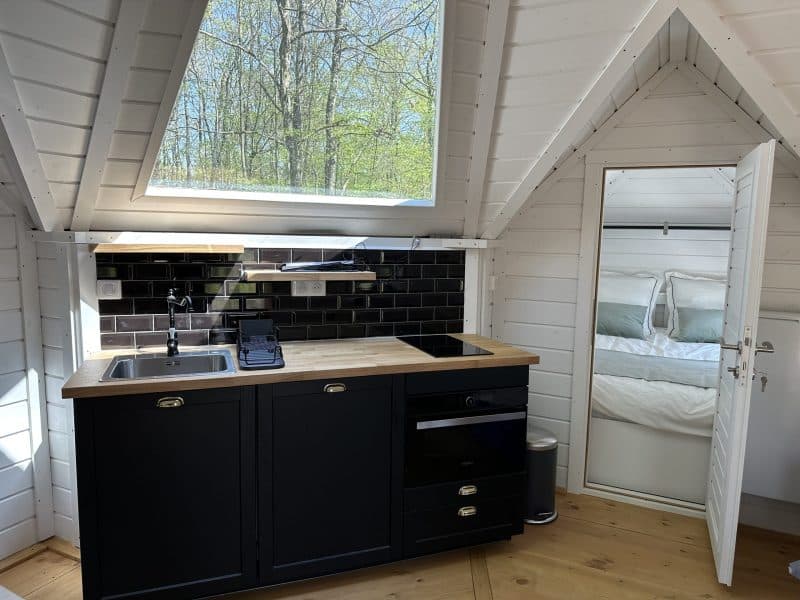 Chalet moderne avec cuisine équipée et vue sur la nature. Ambiance chaleureuse et lumineuse.