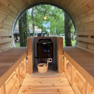Hébergement insolite en forme de tonneau, intérieur en bois chaleureux et lumineux.