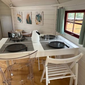 Hébergement insolite en Île-de-France : chalet lumineux avec table élégante et décor moderne.