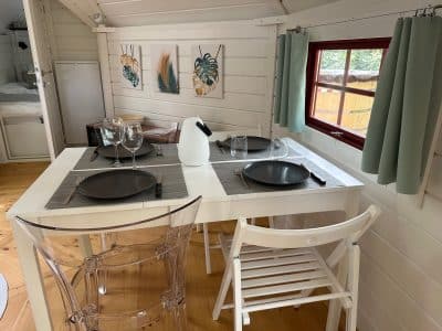 Hébergement insolite en Île-de-France : chalet lumineux avec table élégante et décor moderne.