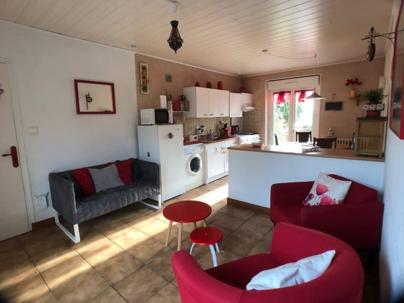 Appartement cosy avec cuisine équipée et salon lumineux, décoré de couleurs vives.
