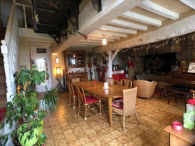 Gîte chaleureux avec une grande salle à manger en bois et une cheminée accueillante.