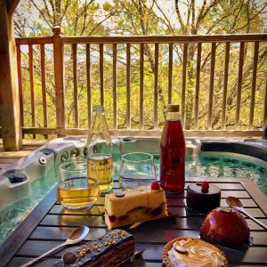 Hébergement insolite en Midi-Pyrénées avec jacuzzi et douceurs sucrées sur une table.