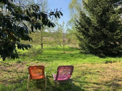 Hébergement insolite en pleine nature, chaises colorées face à un paysage verdoyant.