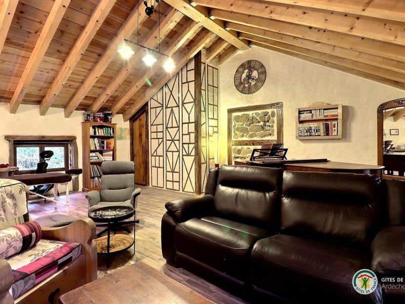 Gîte chaleureux en bois avec un salon confortable et une belle lumière naturelle.