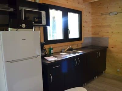 Hébergement insolite en Limousin : cuisine moderne en bois avec fenêtres lumineuses.