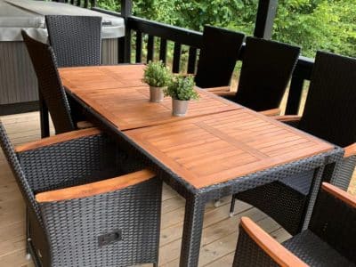 Terrasse en bois avec table et chaises en rotin, hébergement insolite à Limousin.