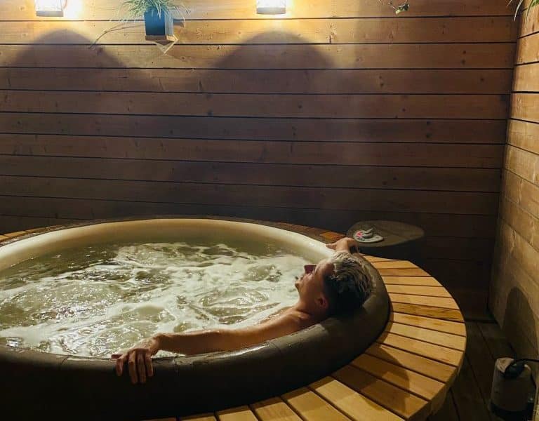 Cabane en bois avec jacuzzi, ambiance chaleureuse et lumineuse pour un séjour relaxant.