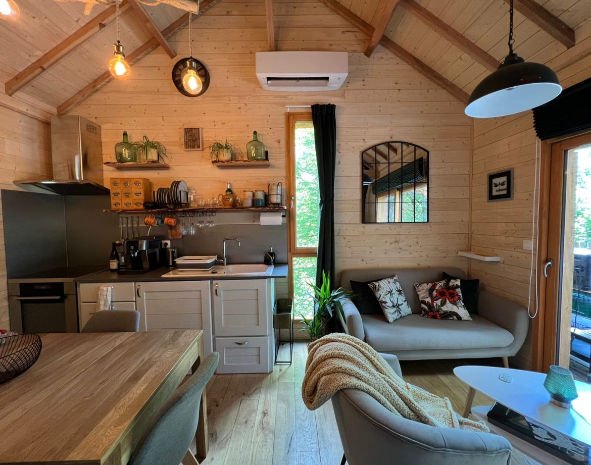 Chalet moderne en bois avec cuisine équipée et décoration chaleureuse.