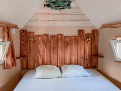 Chambre cocooning en bois dans un hébergement insolite au Limousin, avec lit confortable.