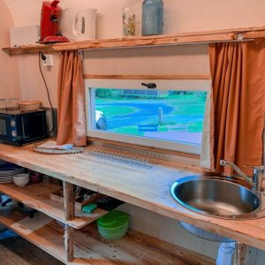 Hébergement insolite à Limousin : cuisine en bois avec vue sur la nature environnante.