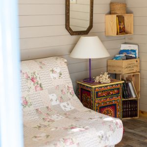 Charmant hébergement insolite en Provence, avec un canapé fleuri et une lampe colorée.