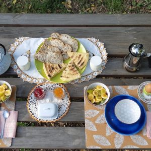 Petit-déjeuner gourmand sur une table en bois, avec des crêpes et du pain frais.