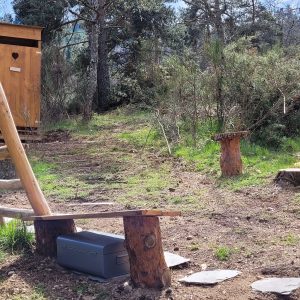 Hébergement insolite en Auvergne-Rhône-Alpes : cabane en bois avec banc en rondins.