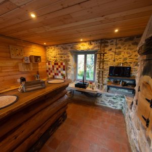 Hébergement insolite en Midi-Pyrénées : intérieur en bois avec cheminée et cuisine équipée.