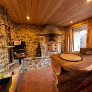 Hébergement insolite en Midi-Pyrénées : chalet en bois avec cheminée en pierre chaleureuse.