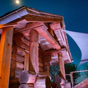 Cabane en bois dans les Midi-Pyrénées, illuminée sous la lune.