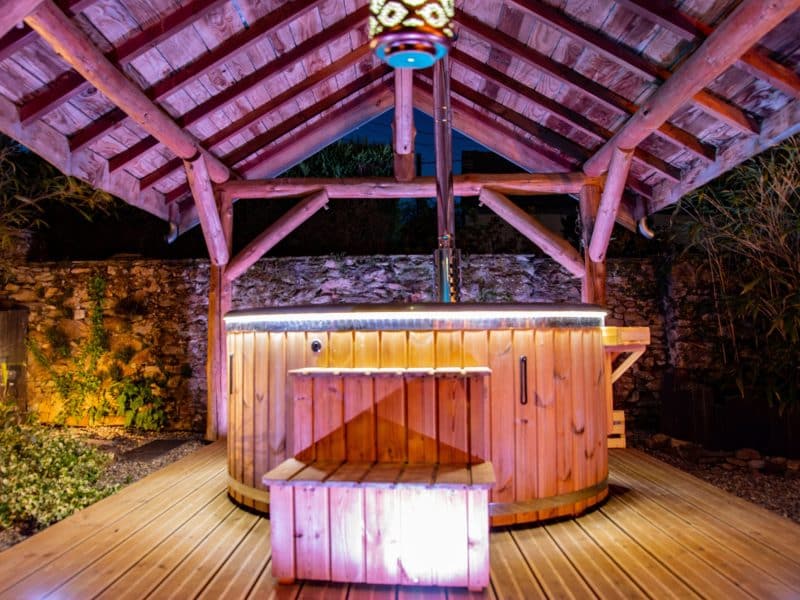 Hébergement en chalet avec un jacuzzi en bois sous une belle structure en bois.