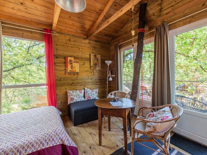 Chalet en bois lumineux avec vue sur la nature et mobilier confortable.