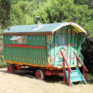 Roulotte colorée en Provence-Alpes-Côte dAzur, entourée de verdure.