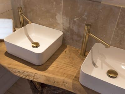 Élégant hébergement insolite en Bretagne avec vasques modernes sur un meuble en bois.
