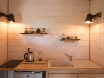 Hébergement insolite en Bretagne : kitchenette en bois avec étagères décoratives.