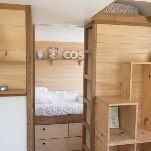 Hébergement insolite en Bretagne : intérieur en bois chaleureux avec lit douillet.