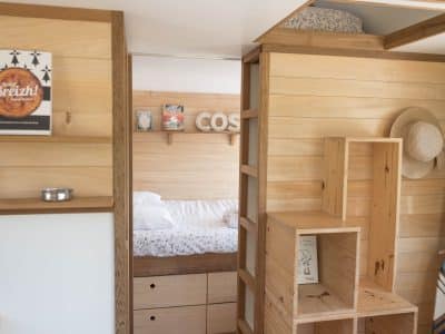 Hébergement insolite en Bretagne : intérieur en bois chaleureux avec lit douillet.