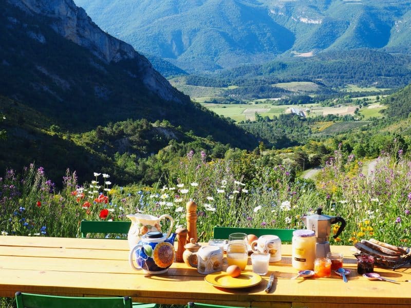 Gîte rural avec vue panoramique sur les montagnes et une table garnie de délices.
