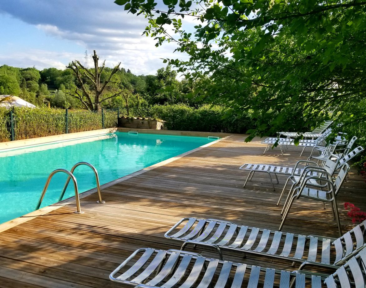 Hébergement insolite en Languedoc-Roussillon avec piscine et chaises longues en bois.