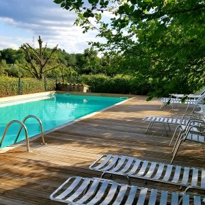 Hébergement insolite en Languedoc-Roussillon avec piscine et chaises longues en bois.