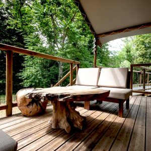 Cabane perchée en Champagne-Ardenne, avec terrasse en bois et table en tronc darbre.
