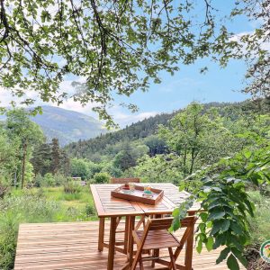 Hébergement insolite en Auvergne-Rhône-Alpes, avec terrasse en bois et vue sur la nature.