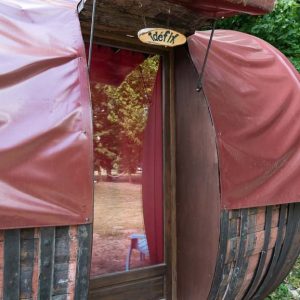 Hébergement insolite en forme de tonneau à Champagne-Ardennes, avec une porte en bois.