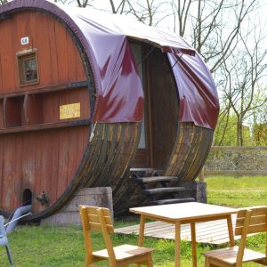 Hébergement insolite en Auvergne : un baril en bois avec une terrasse en bois.