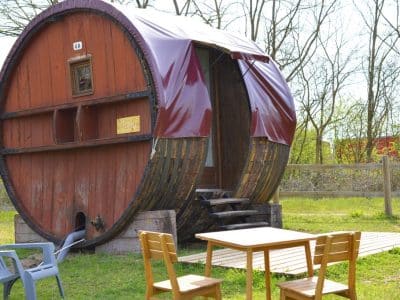 Hébergement insolite en Auvergne : un baril en bois avec une terrasse en bois.
