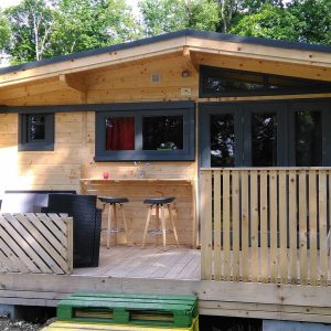 Chalet en bois à Champagne-Ardennes avec terrasse et bar extérieur.