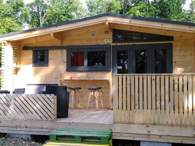 Chalet en bois à Champagne-Ardennes avec terrasse et bar extérieur.