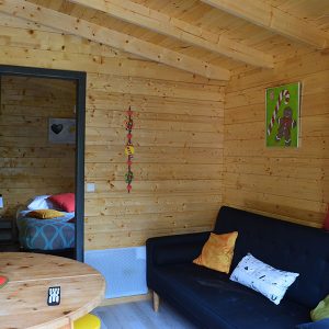 Chalet en bois chaleureux avec salon confortable et décoration colorée.