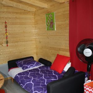 Chalet en bois cosy à Champagne-Ardenne, avec lit coloré et décoration moderne.