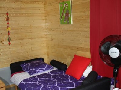 Chalet en bois cosy à Champagne-Ardenne, avec lit coloré et décoration moderne.